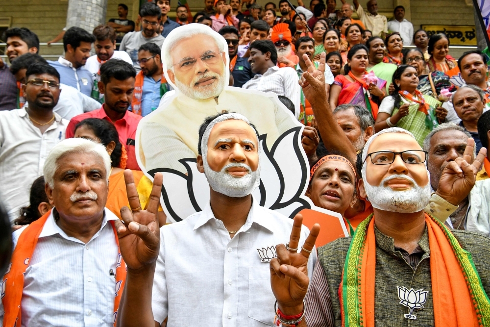 Indian supporters and party workers of Bharatiya Janata Party (BJP) wear masks of Indian Prime Minister Narendra Modi and flash victory signs as they celebrate on the vote results day for India's general election in Bangalore on Thursday. Indian Prime Minister Narendra Modi looked on course for a major victory in the world's biggest election, with early trends suggesting his Hindu nationalist party will win a bigger majority even than 2014. — AFP