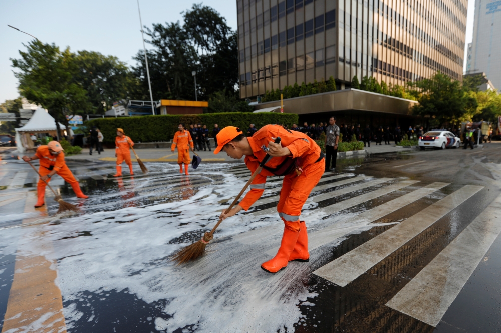 Workers clean the road after a riot outside Indonesia's Election Supervisory Agency (Bawaslu) headquarters following the announcement of last month's presidential election results in Jakarta, Indonesia, Thursday. — Reuters