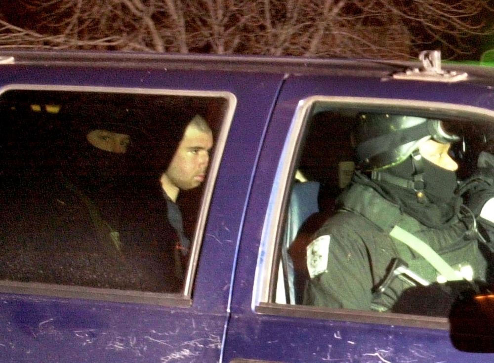 US-Taliban fighter John Walker Lindh, second left, rides in the back seat with security officers as they arrive at the Alexandria Detention Center in Alexandria, Virginia, in this Jan. 23, 2002 file photo. — AFP