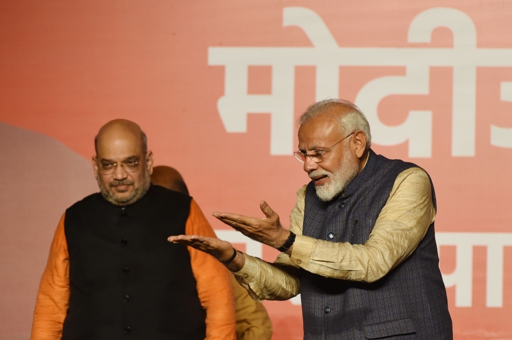 India Prime Minister Narendra Modi (R) gestures to supporters next to Bharatiya Janta Party (BJP) president Amit Shah wave as they celebrate the victory in India's general election at the party headquarters in New Delhi on Thursday. — AFP