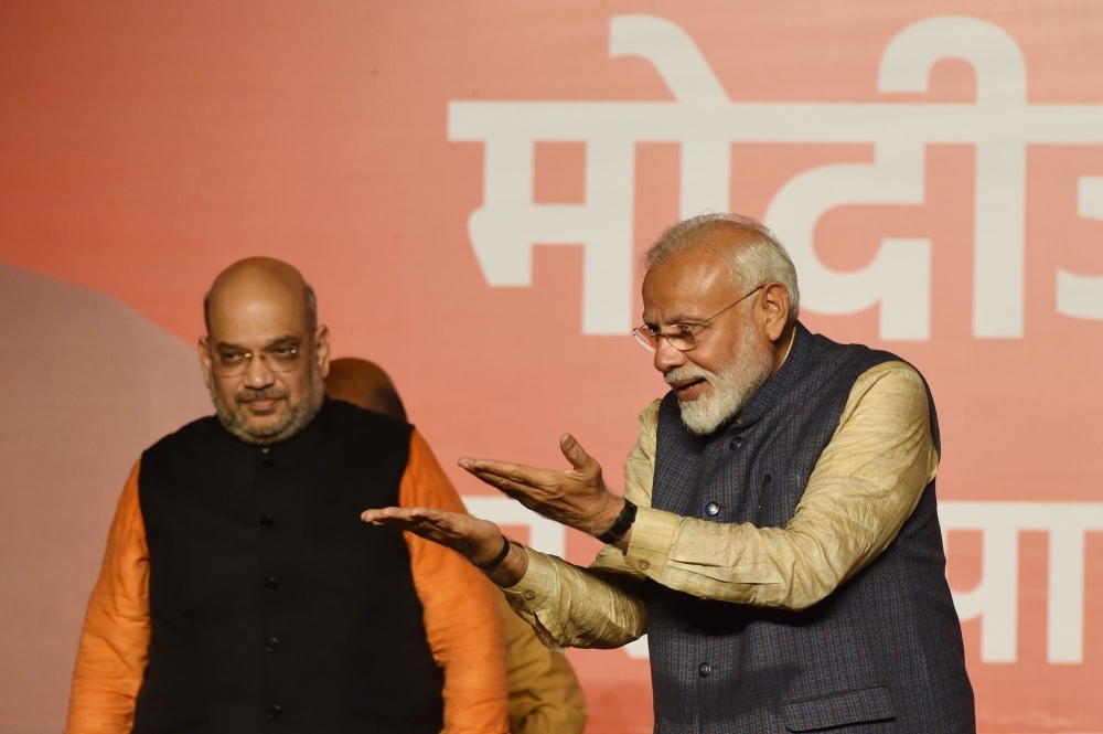 India Prime Minister Narendra Modi (R) gestures to supporters next to Bharatiya Janta Party (BJP) president Amit Shah wave as they celebrate the victory in India's general election at the party headquarters in New Delhi on Thursday. — AFP