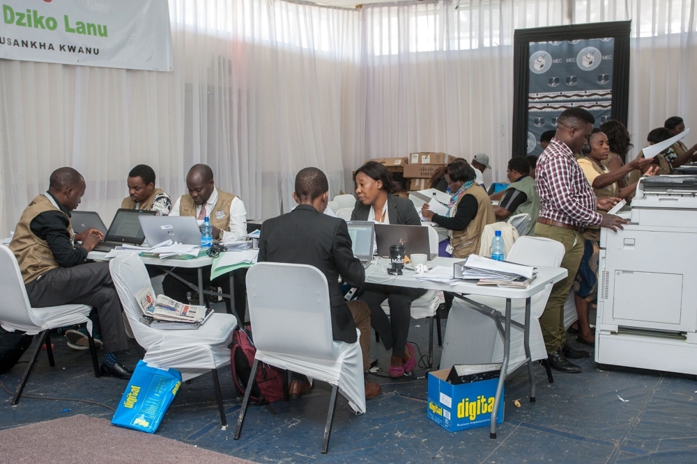 The Malawi Electoral Commission (MEC) staff members work to tabulate and tally votes heavily guarded by military personnel at the National Tally Center following the country's May 21 tripartite elections in Blantyre on Saturday. — AFP