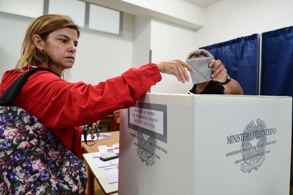 A woman casts her vote for the European elections at a polling station in southern Milan on May 26. - AFP