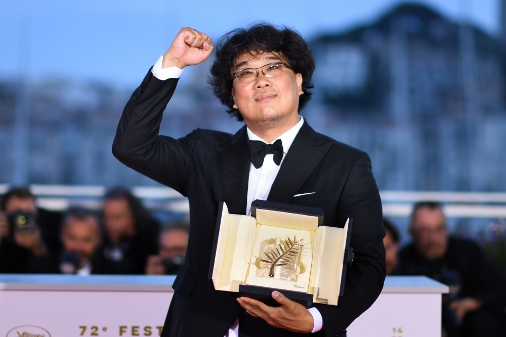 South Korean director Bong Joon-Ho celebrates during a photo-call after he won the Palme d'Or for the film 