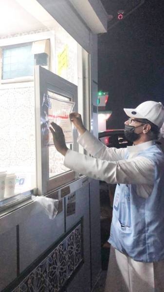 A municipality official pasting the closure notice on one of the eateries in Jeddah. — Okaz photo