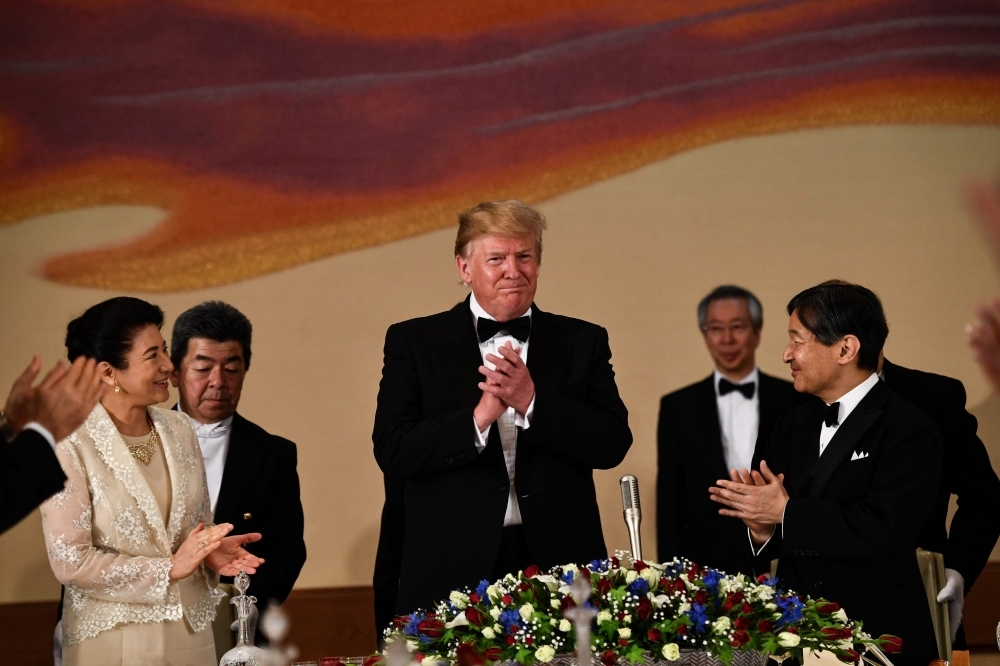 US President Donald Trump (C), Japan's Emperor Naruhito (R) and Empress Masako (L) attend a state banquet at the Imperial Palace in Tokyo on Monday. — AFP