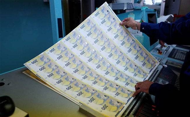 A worker manages sheets of the new 200 euro banknotes in the secretive vaults inside the Bank of Italy. 