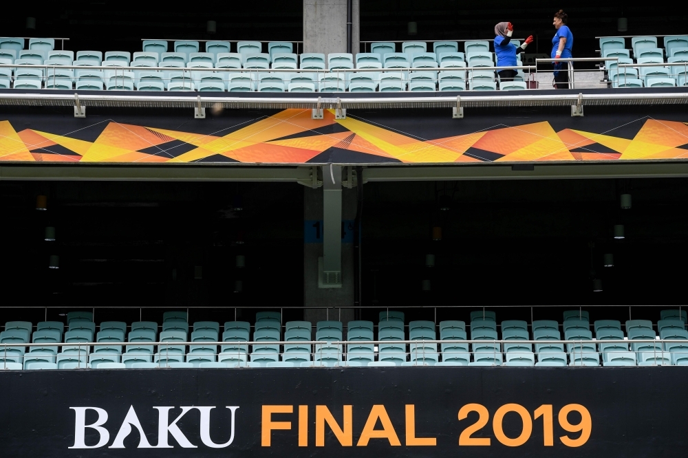 Workers clean the tribune inside Baku Olympic stadium on the eve of the UEFA Europa league final match between Arsenal and Chelsea, in Baku on Tuesday. — AFP