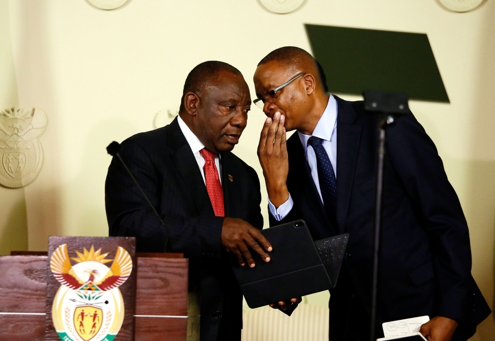 South African President Cyril Ramaphosa (L) listens to Director General in the Presidency Dr Cassius Lubisi (R) after announcing the composition of the national executive at the Union Buildings on Wednesday in Pretoria, South Africa. — AFP