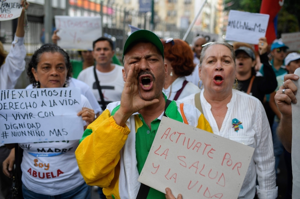 Medical personnel, parents and patients of the Jose Manuel de los Rios Hospital take part in a protest due to the death of the fourth child in a month, in front of the institution in Caracas, on Wednesday. — AFP