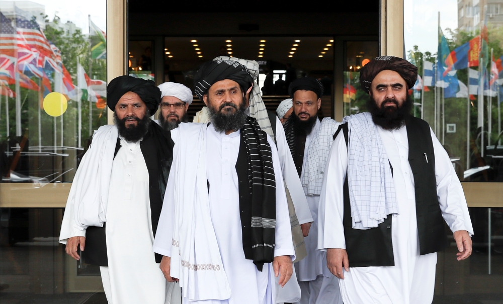 Members of a Taliban delegation, led by chief negotiator Mullah Abdul Ghani Baradar, center, front, leave after peace talks with Afghan senior politicians in Moscow, Russia, on Thursday. — Reuters