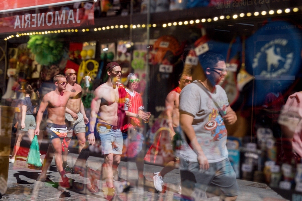 Liverpool supporters are reflected in a shop window in Madrid on Friday on the eve of the UEFA Champions League final football match against Tottenham Hotspur. — AFP