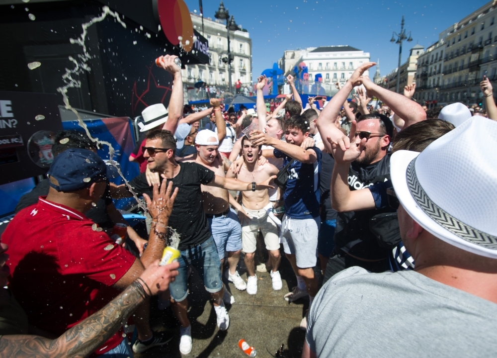 Liverpool supporters are reflected in a shop window in Madrid on Friday on the eve of the UEFA Champions League final football match against Tottenham Hotspur. — AFP