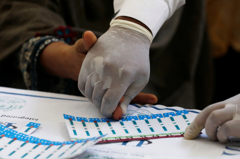 A medical worker helps a woman to draw blood for a HIV test at the free medical camp in Ratodero, Pakistan, in this May 25, 2019 file photo. — Reuters