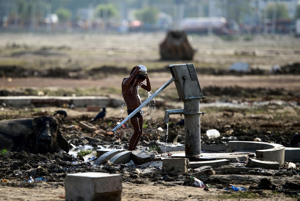 An Indian homeless child takes a bath from a hand pump as he tries to cool himself on a hot summer afternoon in Allahabad. Temperatures pushed toward 50 degrees Celsius (122 Fahrenheit) across much of India on Saturday as an unrelenting heatwave triggered warnings of water shortages and heat stroke. — AFP photos