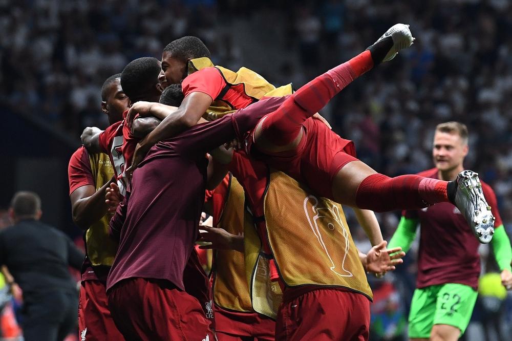 Liverpool's Belgian forward Divock Origi (L) celebrates with teammates after scoring his team's second goal during the UEFA Champions League final football match between Liverpool and Tottenham Hotspur at the Wanda Metropolitano Stadium in Madrid on Saturday. — AFP
