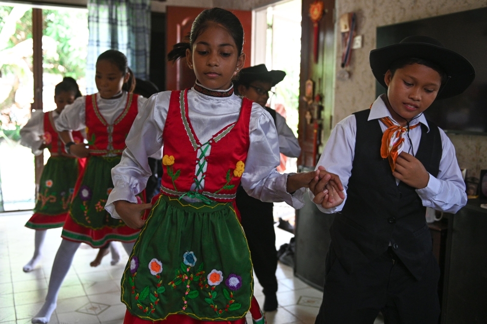 Students dressed in traditional Portuguese outfits dance before learning the Kristang language at the Portuguese Settlement in Ujong Pasir, Malacca, in this May 11, 2019 file photo. — AFP