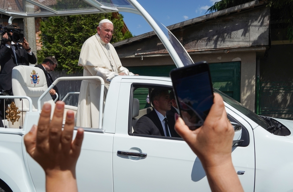 Pope Francis arrives in an open vehicle to meet with members of the Roma community in the Barbu Lautaru district of Blaj, Romania, on Sunday. — AFP