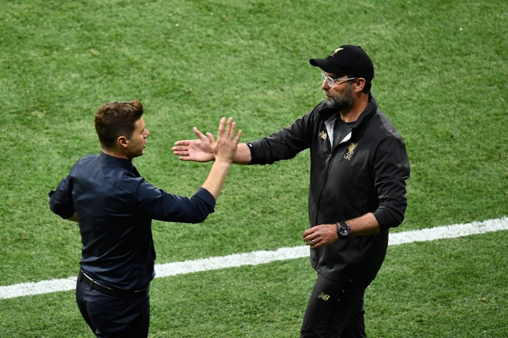 Liverpool's German manager Jurgen Klopp (R) is congratulated by Tottenham Hotspur's Argentinian head coach Mauricio Pochettino after his team won the UEFA Champions League final football match at the Wanda Metropolitan Stadium in Madrid on Saturday. — AFP