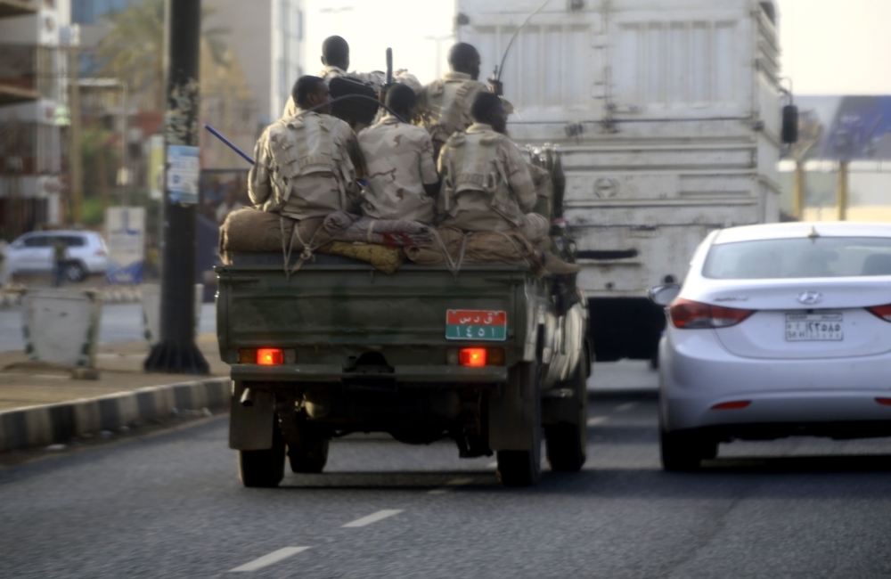 Sudanese security forces ride in the back of a pick up truck through a main avenue in Khartoum on Tuesday. — AFP