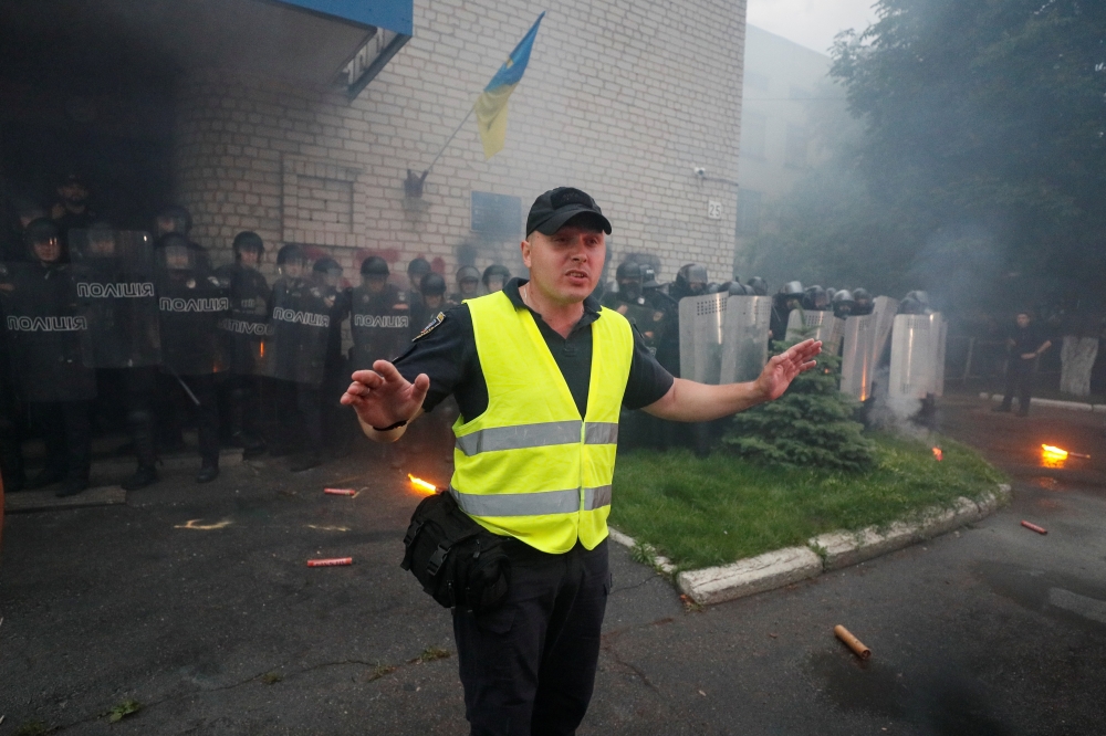 A law enforcement officer addresses protesters near a local police station following a recent incident involving Kyrylo Tliavov, a five-year-old boy who was allegedly shot by drunken police officers and later died in a hospital, in Pereiaslav-Khmelnytskyi in Kiev Region, Ukraine, on Tuesday. — Reuters
