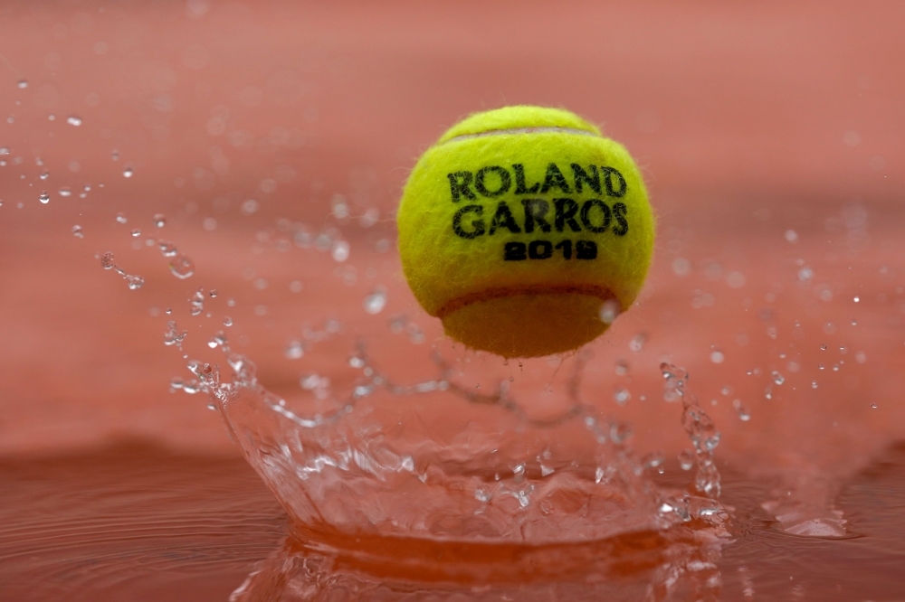 A 2019 French Open tennis tournament official ball bounces on a cover as rain falls on day eleven of The Roland Garros 2019 French Open tennis tournament in Paris on Wednesday. — AFP
