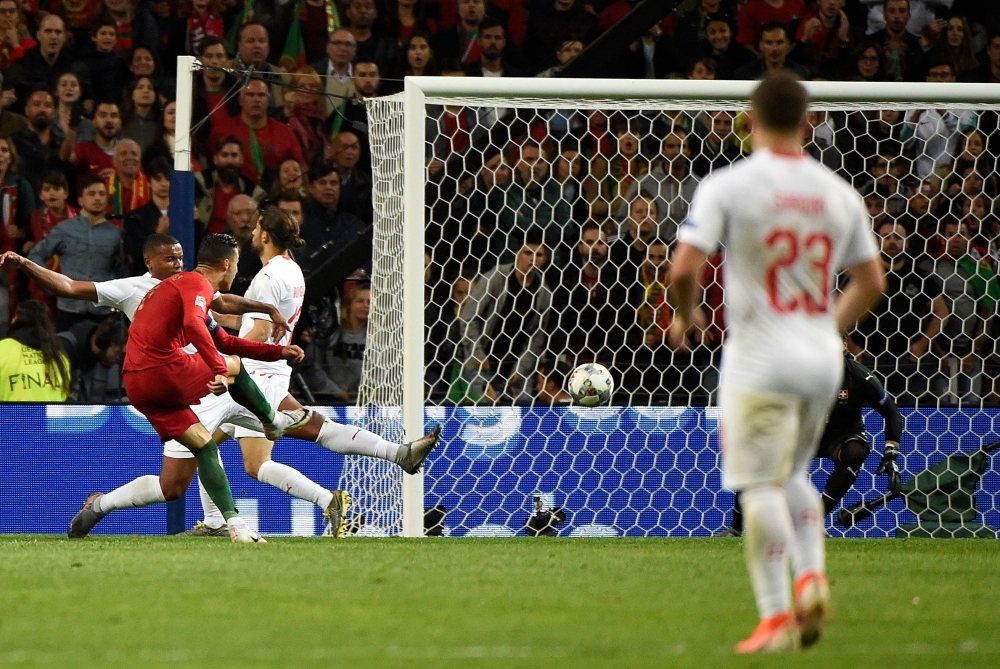 Portugal's forward Cristiano Ronaldo scores his third goal during the UEFA Nations League semifinal football matchagainst Switzerland at the Dragao stadium in Porto on Wednesday. — AFP