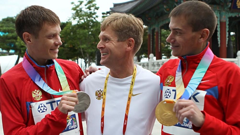 Russian race walking coach Viktor Chegin, center, who was banned for life for doping in 2016, has won state contracts to provide security at a sports venue where he was formerly head coach, procurement documents and tax records show.