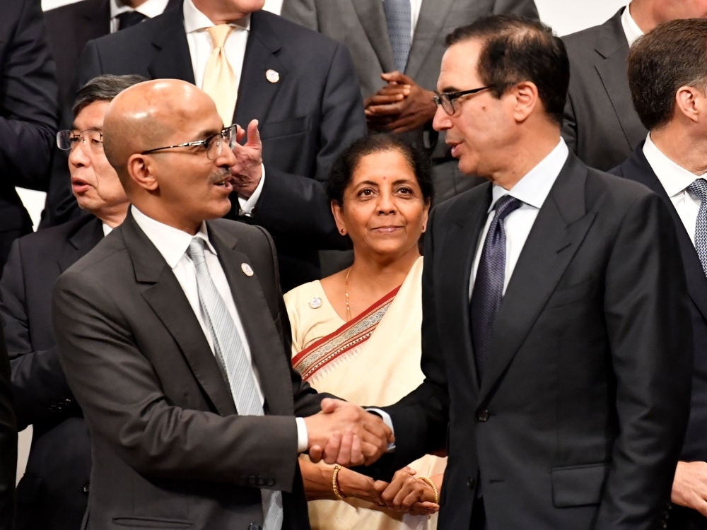 US Treasury Secretary Steven Mnuchin (R) shakes hands with Saudi Arabia's Finance Minister Mohammed Al Jadaan (L) while attending a family photo session at the G20 finance ministers and central bank governors meeting in Fukuoka on Sunday. — AFP