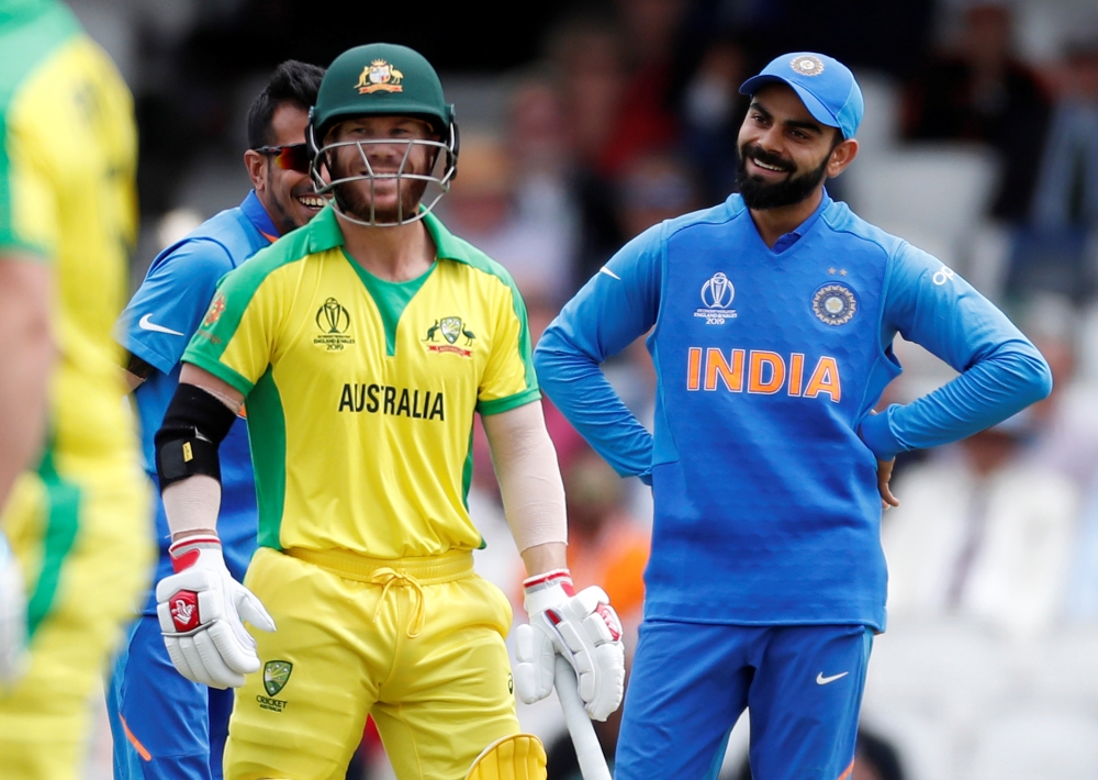 India's Virat Kohli and Australia's David Warner share a joke after the ball hit the stumps but the bails don't fall off during the ICC Cricket World Cup match at The Oval, London, Britain, on Sunday. — Reuters/Paul Childs
