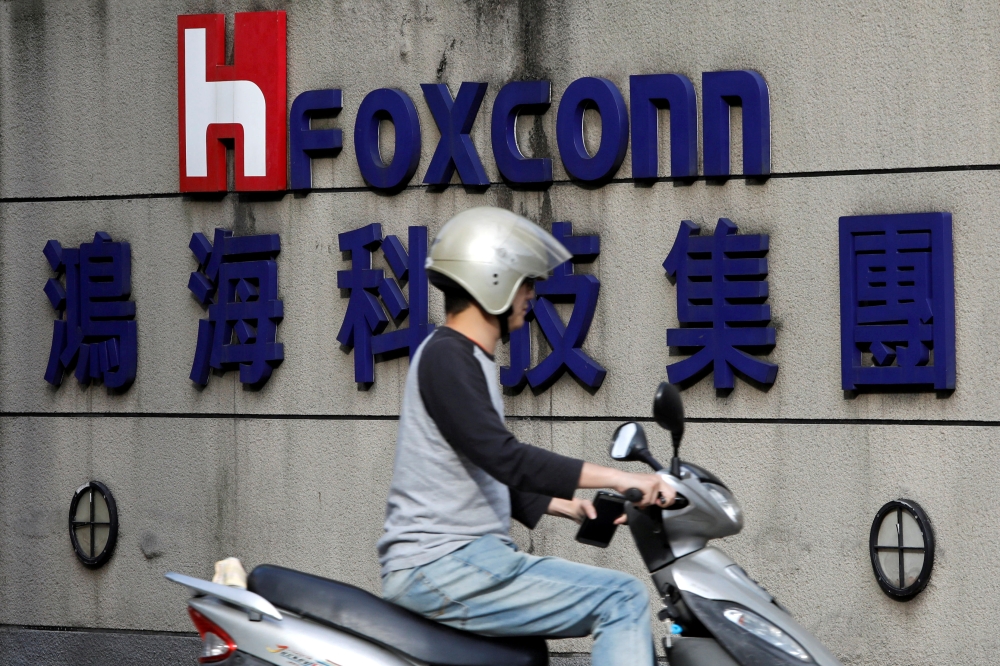 A motorcyclist rides past the logo of Foxconn, the trading name of Hon Hai Precision Industry, in Taipei, Taiwan, in this March 30, 2018 file photo. — Reuters