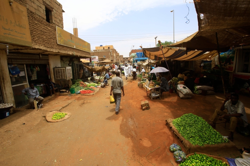Sudanese residents walk in the central market of Khartoum on Monday, as most of the shops and businesses remained shut. — AFP