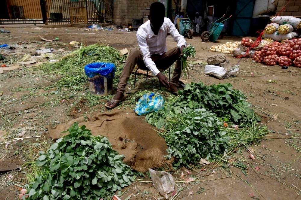 A Sudanese vendor sells vegetables in the central market of Khartoum as most of the shops and businesses remained shut. — AFP