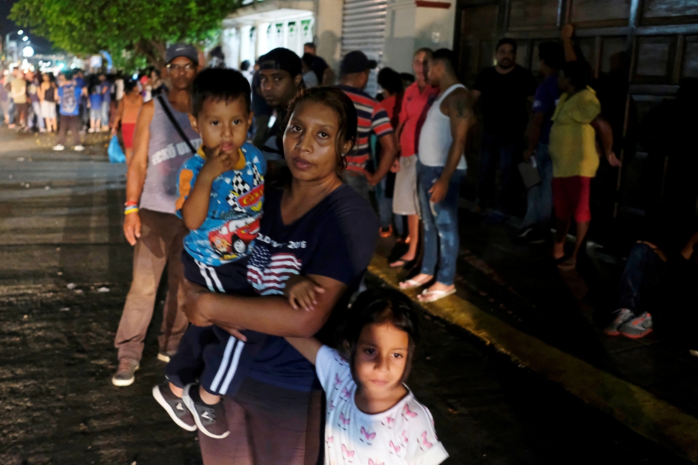 Central American migrants wait outside the Mexican Commission for Refugee Aid (COMAR) in Tapachula, Mexico. — Reuters