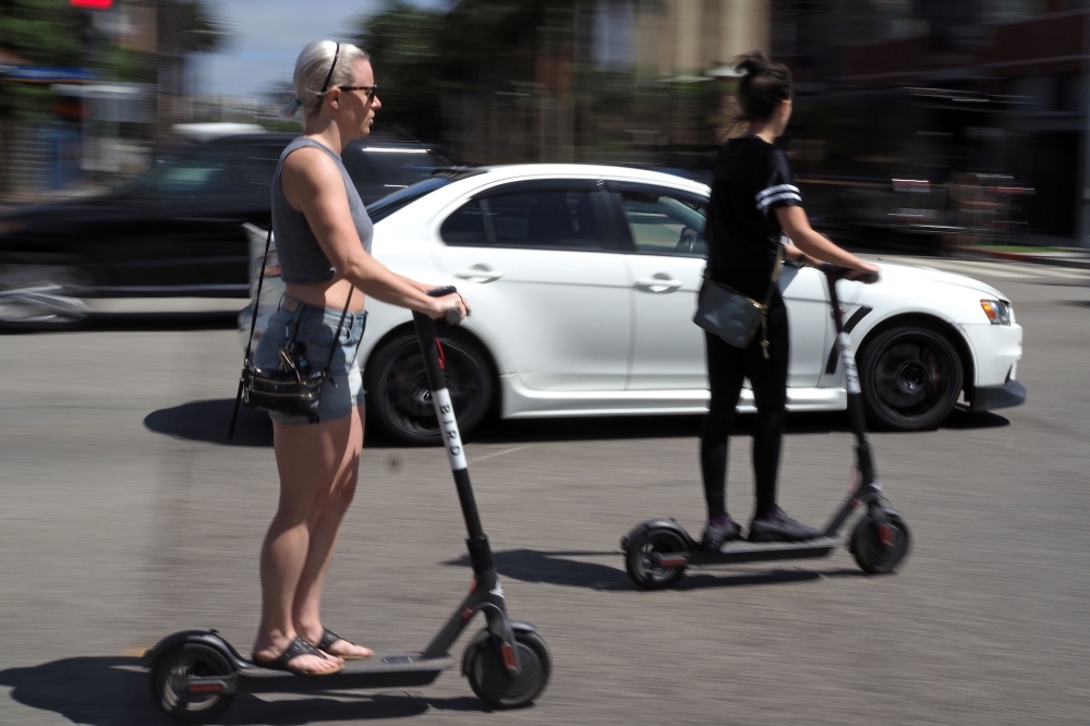 In this file photo taken on July 13, 2018 shared electric scooters are parked on a street in Santa Monica, California. American electric scooter company Bird bought competitor Scoot Wednesday, a move that will allow the rideshare company to return to San Francisco. — AFP