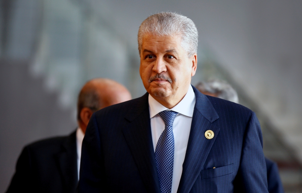 A Protester is pushed back by policemen as Algeria's former prime minister Abdelmalek Sellal is driven to custody at the El Harrach prison in the suburbs of the capital Algiers, on Thursday. Sellal was remanded in custody after appearing before a judge as part of an anti-corruption investigation, state media reported. — AFP