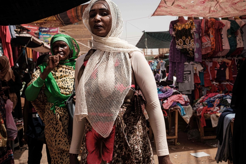 Women walk through a market street in the Sudanese capital Khartoum's twin city Omdurman on Thursday, as life returns to normal in the Sudanese capital Khartoum. — AFP