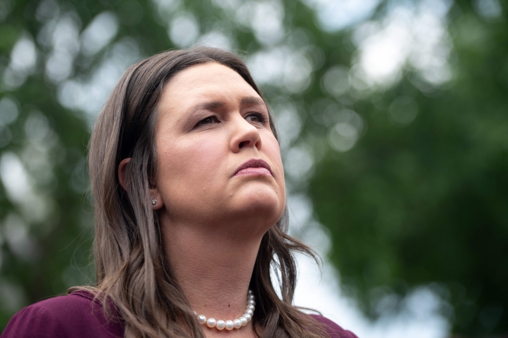 In this file photo, US President Donald Trump (L) embraces White House Press Secretary Sarah Huckabee Sanders during a Make America Great Again rally in Green Bay, Wisconsin. — AFP