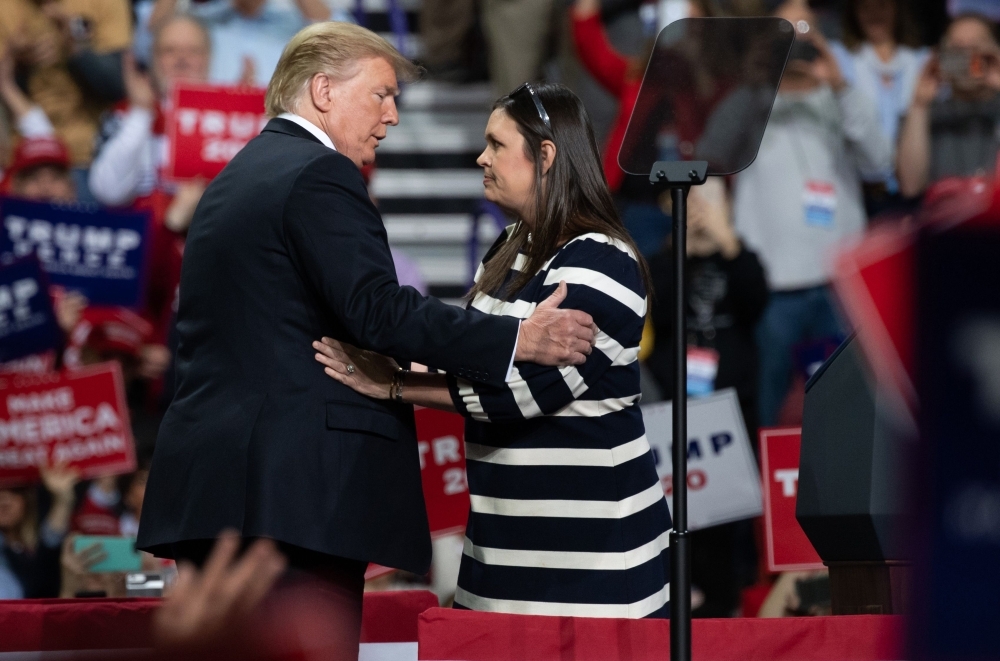 In this file photo, US President Donald Trump (L) embraces White House Press Secretary Sarah Huckabee Sanders during a Make America Great Again rally in Green Bay, Wisconsin. — AFP