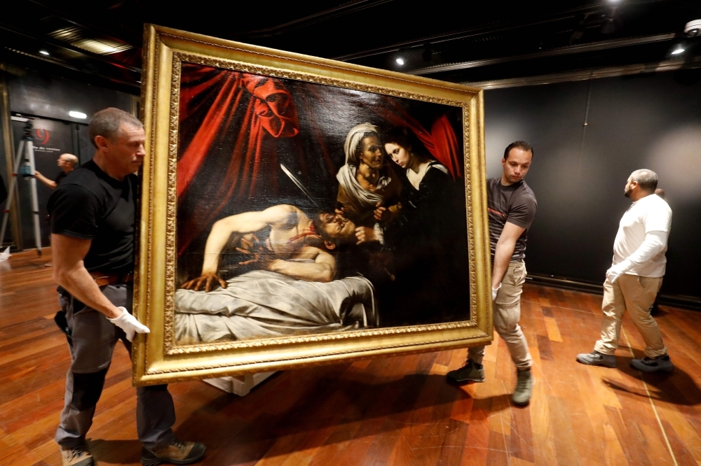 Workers carry a painting believed by some experts to be Caravaggio's 