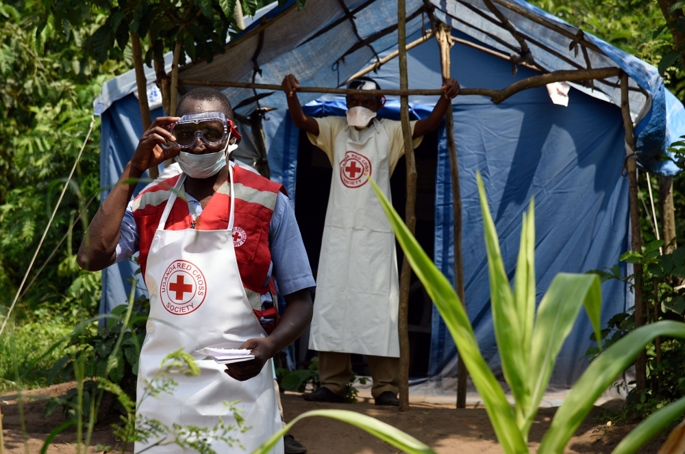 Health workers stand at a non-gazetted crossing point in the Mirami village, near the Mpondwe border check point between Uganda and the Democratic Republic of Congo, Friday. — AFP 
