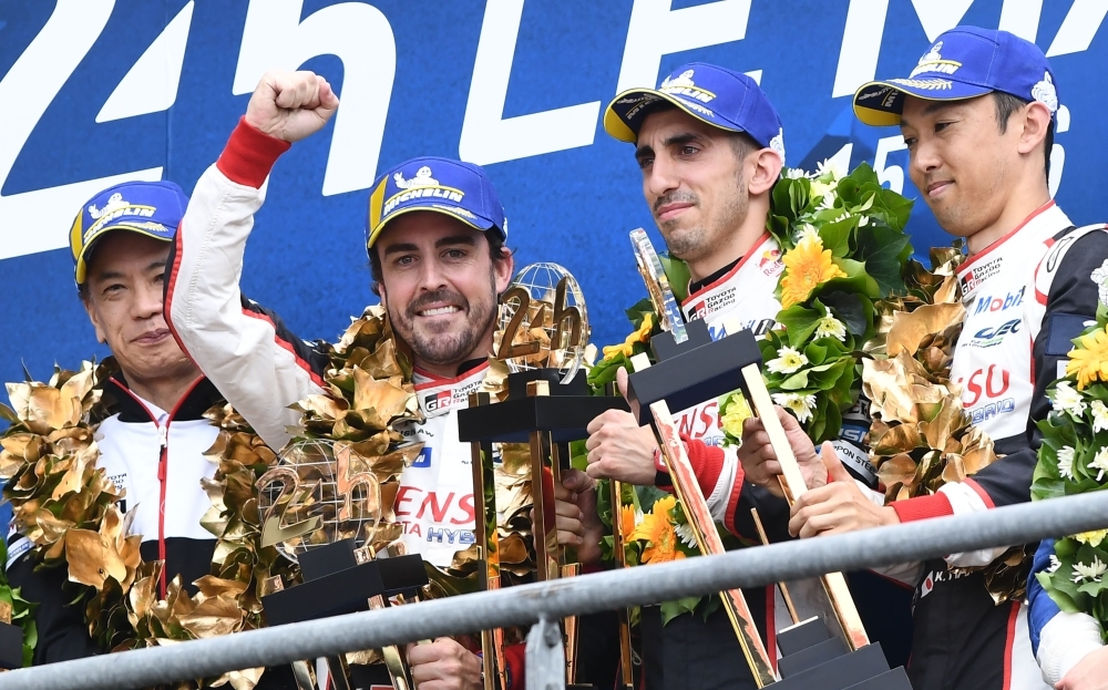 Toyota TS050 Hybrid LMP1 of Japanese's driver Kazuki Nakajima (R) Spain's driver Fernando Alonso (2L) and Switzerland's driver Sebastien Buemi (2R) celebrates on podium after winning in the 87th edition of the 24 Hours Le Mans endurance race on Sunday, at Le Mans northwestern France. — AFP 