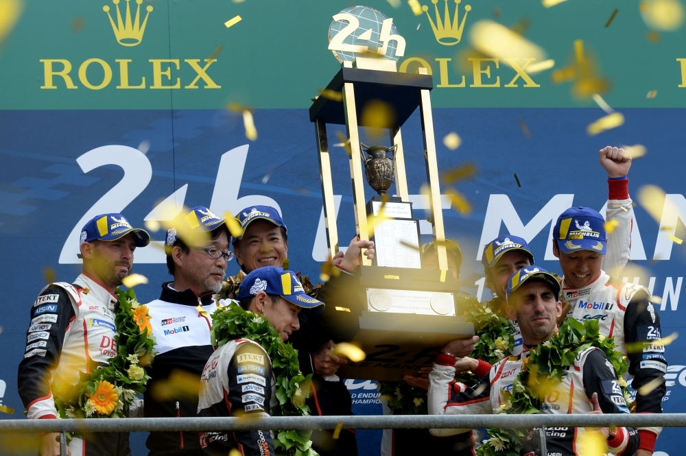 Toyota TS050 Hybrid LMP1 of Japanese's driver Kazuki Nakajima (R) Spain's driver Fernando Alonso (2L) and Switzerland's driver Sebastien Buemi (2R) celebrates on podium after winning in the 87th edition of the 24 Hours Le Mans endurance race on Sunday, at Le Mans northwestern France. — AFP 
