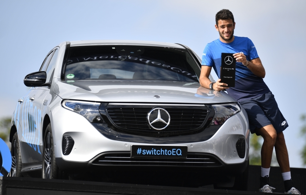 Italy's Matteo Berrettini poses with his trophy next to the full electric Mercedes-Benz EQC Edition 1886 that he won after defeating Canada's Felix Auger-Aliassime in their final at the ATP Mercedes Cup tennis tournament in Stuttgart, southwestern Germany, on Sunday. — AFP