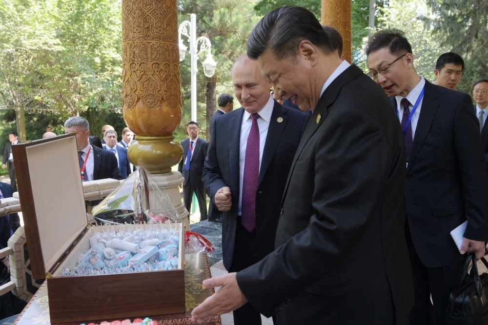 Russian President Vladimir Putin, left, and Chinese President Xi Jinping, right, look at ice creams before the fifth regular foreign ministers' meeting of the Conference on Interaction and Confidence Building Measures in Asia (CICA) at the Diaoyutai State Guesthouse in Dushanbe on Saturday. — AFP
