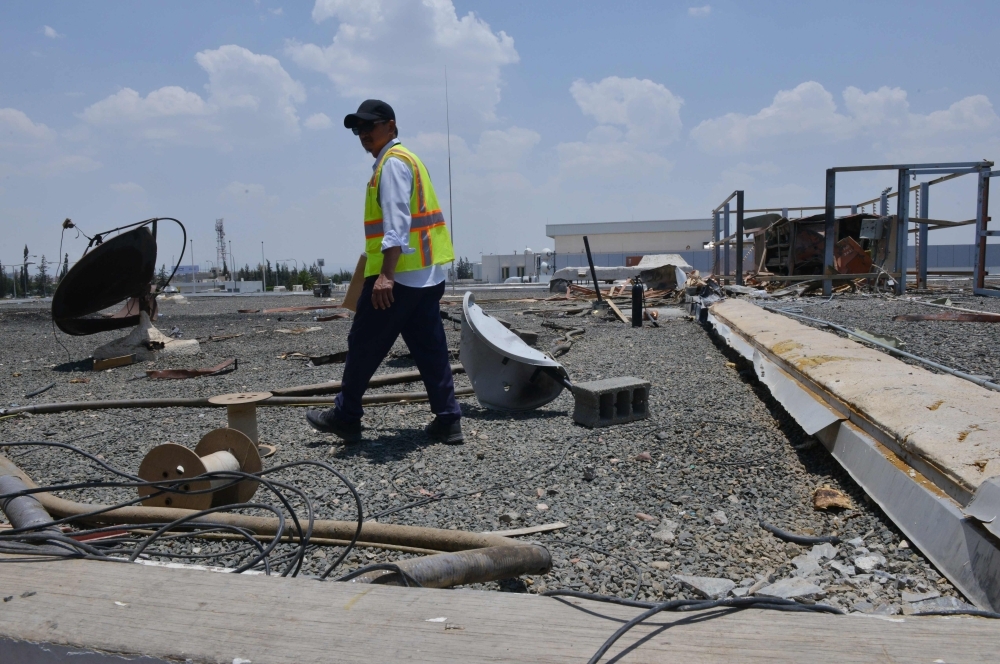 A picture taken on June 13 shows a worker inspecting the damage at Abha airport, one day after a Yemeni rebel missile attack on the civil airport, wounding 26 civilians. — AFP