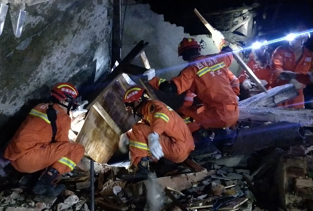 Rescuers search for earthquake survivors in the rubble of a building in Yibin, in China's southwest Sichuan province, early on Tuesday. — AFP