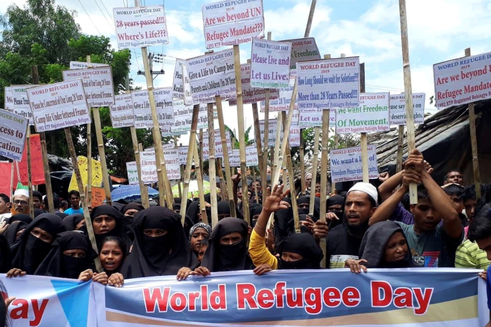 Rohingya refugees hold placards as they participate in a rally to observe World Refugee Day at the Rohingya refugee camp in Cox's Bazar, Bangladesh, on Thursday. — Reuters