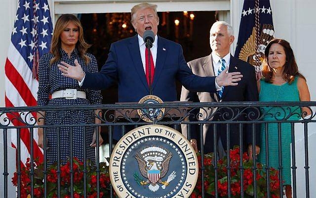 US President Donald Trump, with first lady Melania Trump (left) and Vice President Mike Pence (right) and his wife Karen, speaks from the Truman Balcony of the White House during the annual Congressional Picnic on the South Lawn, Friday. — AFP