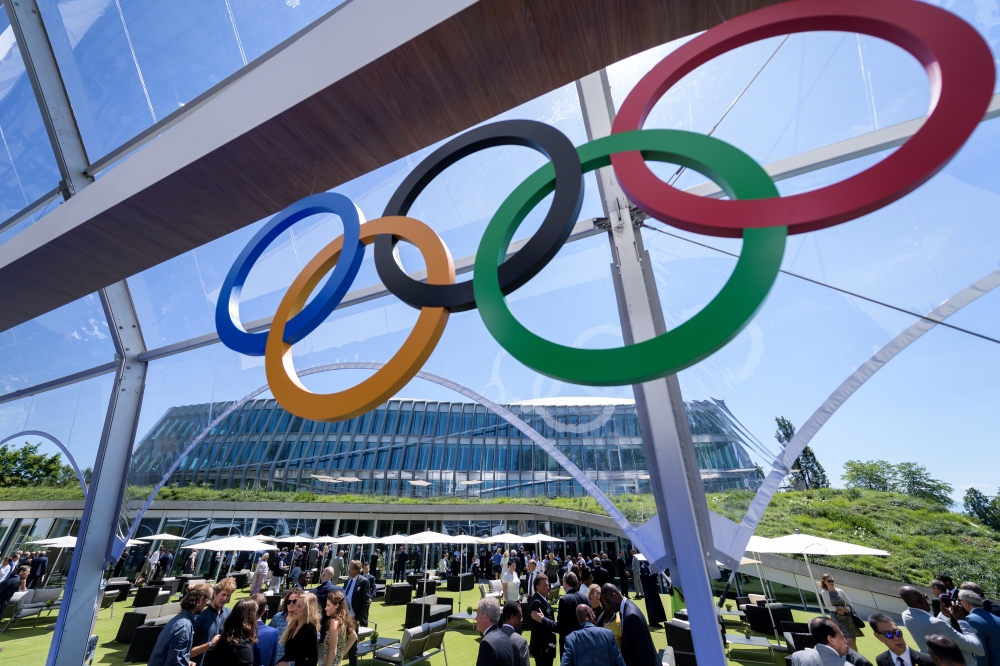 International Olympic Committee (IOC) President Thomas Bach (C) raises the key next to senior architect Jan Ammundsen (L) during the inauguration of the new IOC headquarters in Lausanne, Switzlerland, Sunday ahead of the decision on 2026 Winter Games host. — Reuters